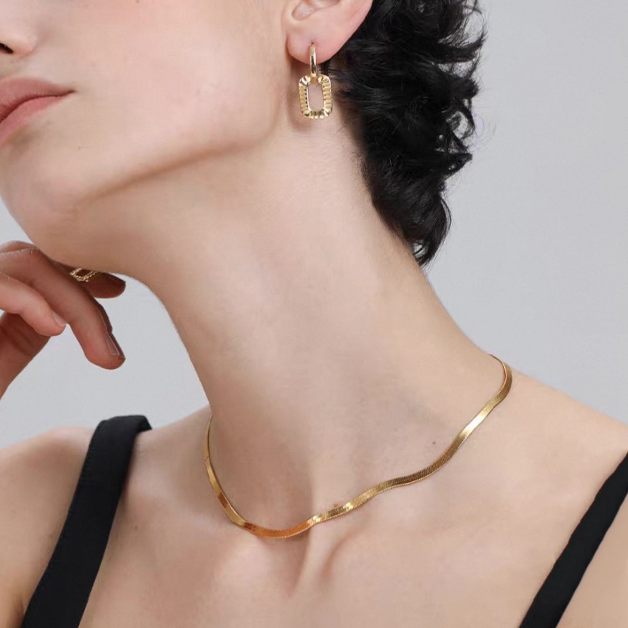 Minimalist snake chain choker Necklace waterproof worn elegantly with gold earrings.